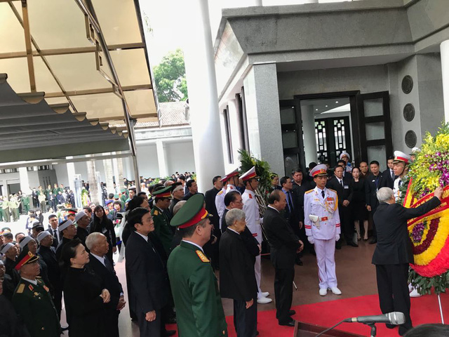  Tổng Bí thư Nguyễn Phú Trọng chỉnh lại vòng hoa trước khi vào viếng. 