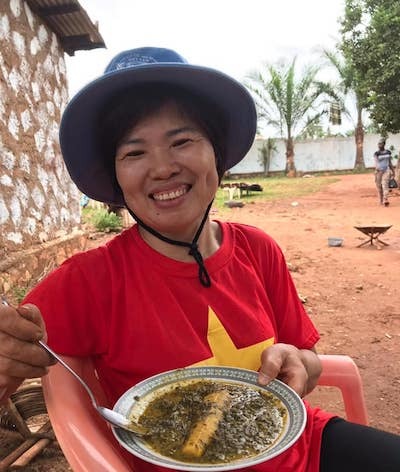 Trung tá Nguyễn Thị Liên dùng thử món bột sắn nấu chuối sau một buổi làm vườn được chủ nhà thết đãi. Ảnh: Nhân vật cung cấp